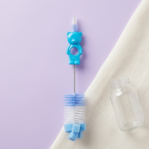 Blue double-ended nipple brush cleaning inside a baby bottle nipple
